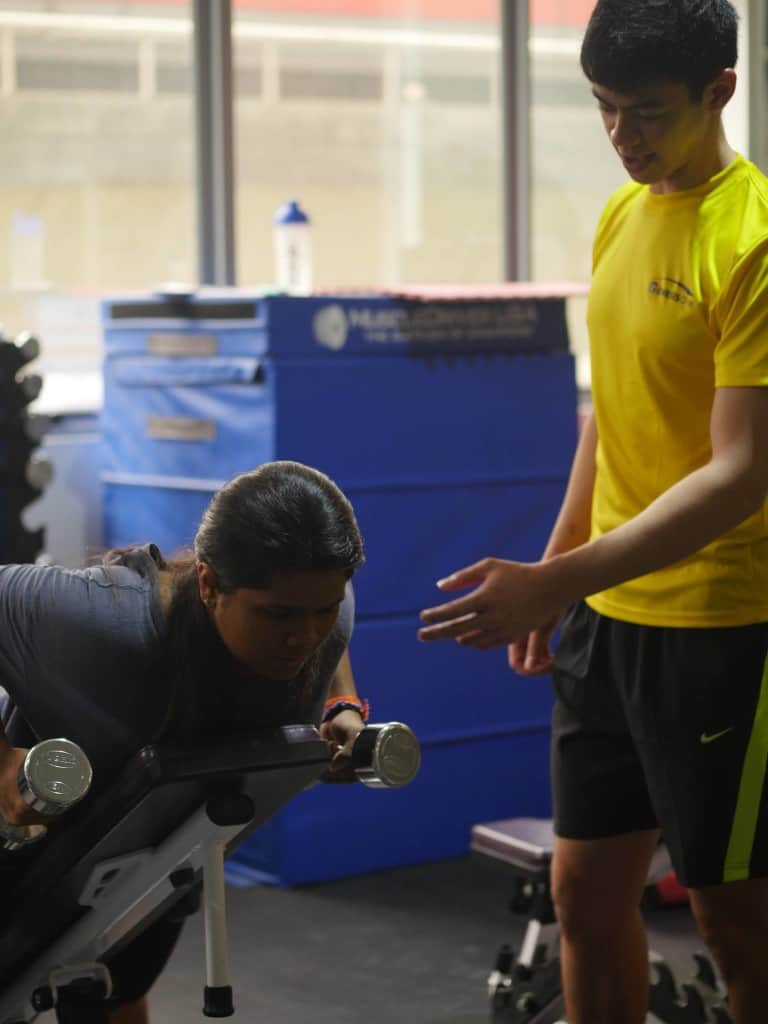 personal trainer singapore checks clients exercise form